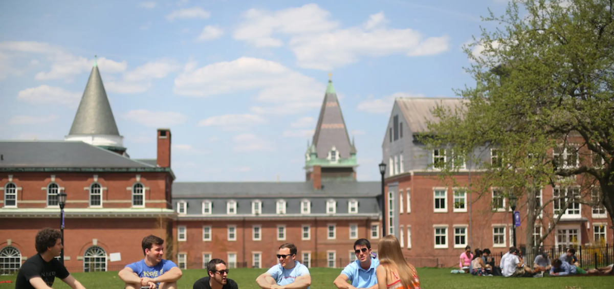 college students sitting on grass