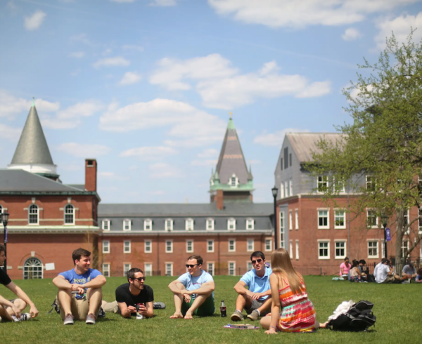 college students sitting on grass